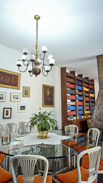 Biblioteca histórica com estante colorida e mesa de refeições