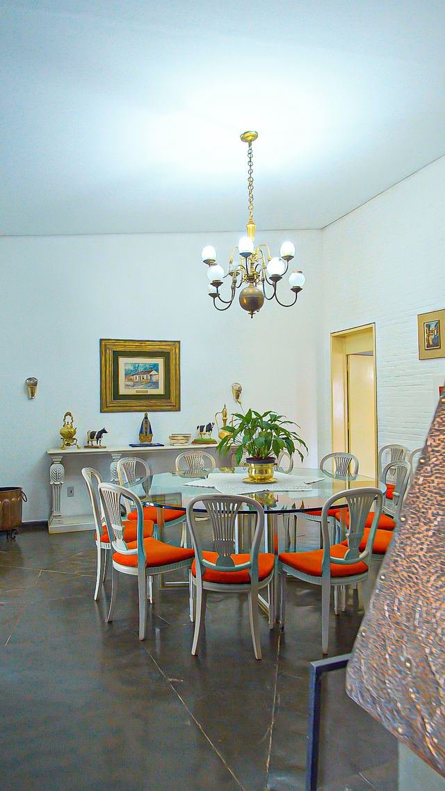 Sala de jantar histórica com lustre e cadeiras laranja