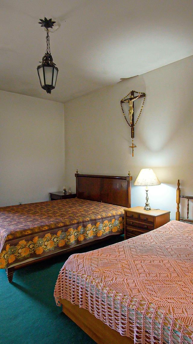 Quarto histórico com cama de madeira e abajur